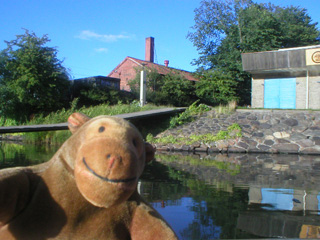 Mr Monkey beside a canoe club house