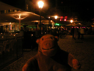 Mr Monkey walking in Lilla Torg after dark