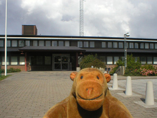 Mr Monkey looking at front door of Ystad police station