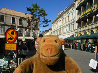Mr Monkey walking up a pedestrianised street