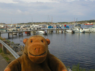 Mr Monkey passing a small jetty with boats moored up