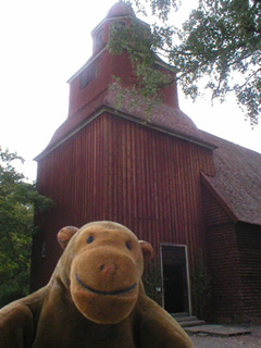 Mr Monkey outside a wooden church
