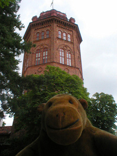 Mr Monkey at the foot of a tall brick tower