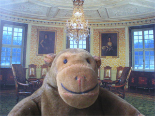 Mr Monkey in front of a picture of the Gilt Leather Room