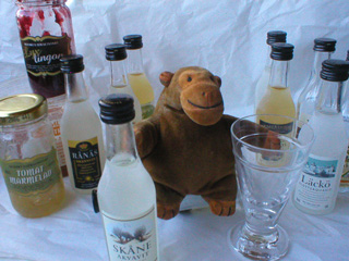 Mr Monkey with a collection of jams, spirits, and an aquavit glass