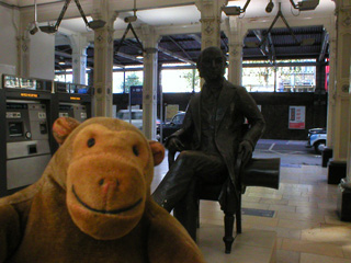 Mr Monkey with a statue of Brunel at Paddington station