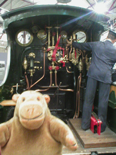 Mr Monkey watching a driver standing on a footplate