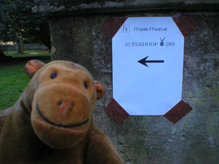 Mr Monkey following a sign taped to a plinth