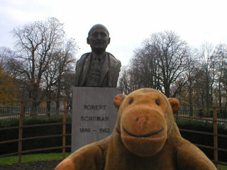 Mr Monkey in front of a bust of Robert Schuman