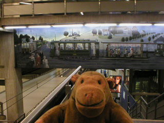Mr Monkey looking at a mural in the Bourse premetro station