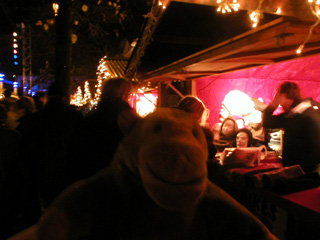 Mr Monkey walking past a Christmas stall