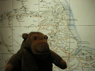Mr Monkey in front of a tiled railway map