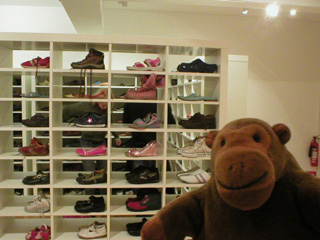 Mr Monkey looking at a shelf of shoes