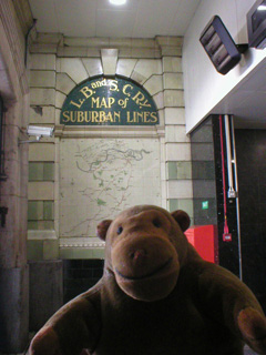 Mr Monkey in front of tile map of L.B. and S.C. railway lines