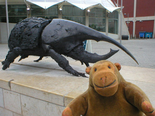 Mr Monkey with a giant beetle statue
