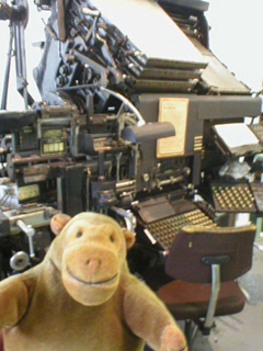 Mr Monkey examining a linotype machine