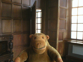 Mr Monkey looking at plain panelling in the small oak room