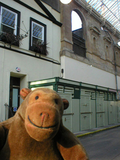 Mr Monkey looking at closed up stalls in St Nicholas market
