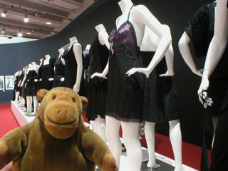 Mr Monkey looking at designer dresses from the other end of the row