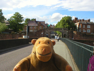 Mr Monkey walking on the Old Dee Bridge towards Bridgegate
