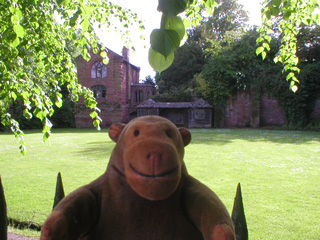 Mr Monkey looking at a small chapel and an abandoned bowling green