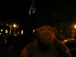 Mr Monkey looking at the tower of the town hall over the buildings of Northgate Street