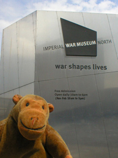 Mr Monkey looking at the sign outside the museum