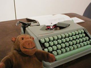 Mr Monkey considering typing a memory of Manchester on an old typewriter