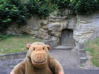 Mr Monkey outside a door in a rock face