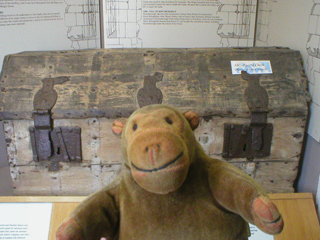Mr Monkey looking at a 14th century record chest