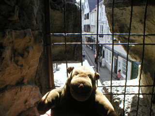 Mr Monkey looking out of an arrow slit at High Petergate