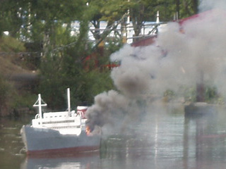 A merchant ship trailing clouds of smoke