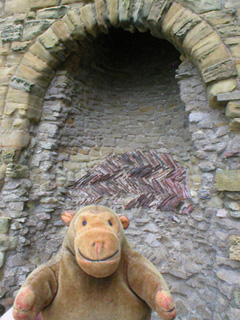Mr Monkey looking at the fireplace in the keep
