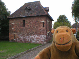 Mr Monkey looking at a small square brick tower