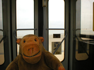 Mr Monkey looking at the doors of a tram