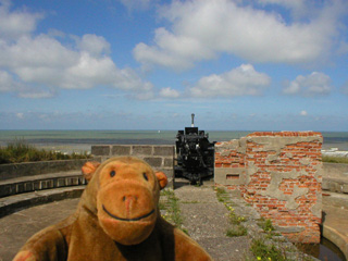Mr Monkey looking at a Flak 36 in the emplacement for a 120mm gun
