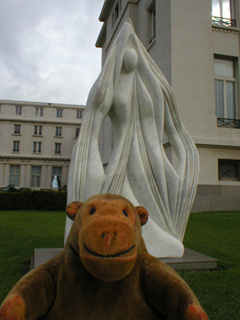 Mr Monkey examining an abstract sculpture of a woman