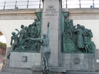 The figures beneath the statue of Leopold II