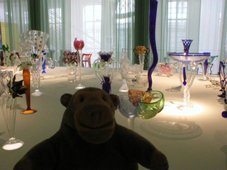 Mr Monkey looking at ornate and colourful glass creations