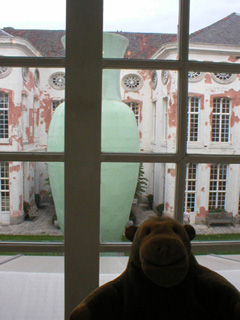 Mr Monkey looking out of a window to see a giant green vase