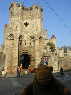Mr Monkey looking across the street at the gate of the Gravensteen