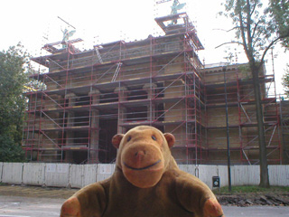 Mr Monkey looking at an art gallery covered in scaffolding