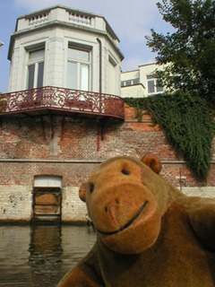 Mr Monkey looking at a teahouse cantilevered over the river