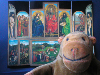 Mr Monkey in front of a postcard of the Mystic Lamb open