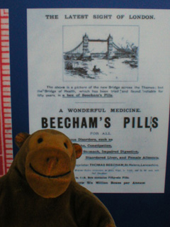 Mr Monkey looking at a poster for Beecham's Pills
