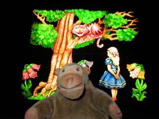 Mr Monkey with a panel showing Alice with the Cheshire Cat